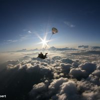 tandem skydiver in freefall with clouds