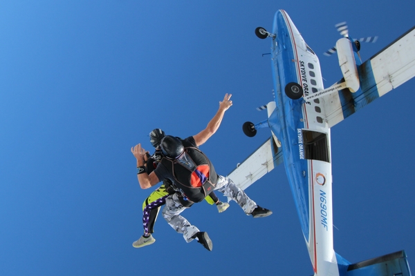 tandem skydiving student exiting plane