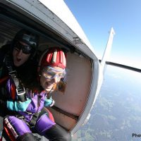 tandem skydiving student about to exit plane