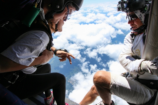 camera flyer prepares to capture tandem skydiving student