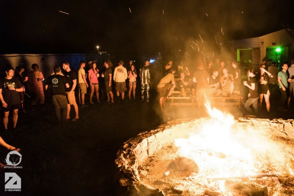 skydivers gather around bonfire at night