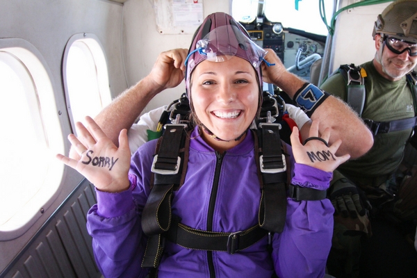 tandem student writes on hands for skydiving video