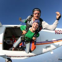 first time skydiver exiting plane with instructor