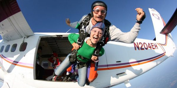 first time skydiver exiting plane with instructor