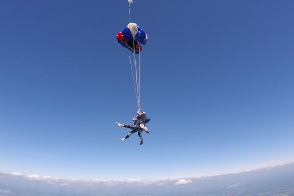 tandem skydiving instructor safely deploys parachute